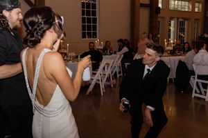 Wedding reception dance floor moments captured in a warmly lit indoor venue.