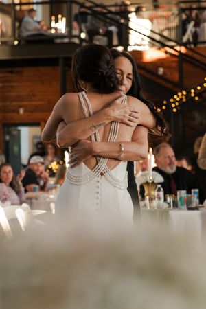 Emotional reception hugs captured in sequence with soft lighting and decorative elements.