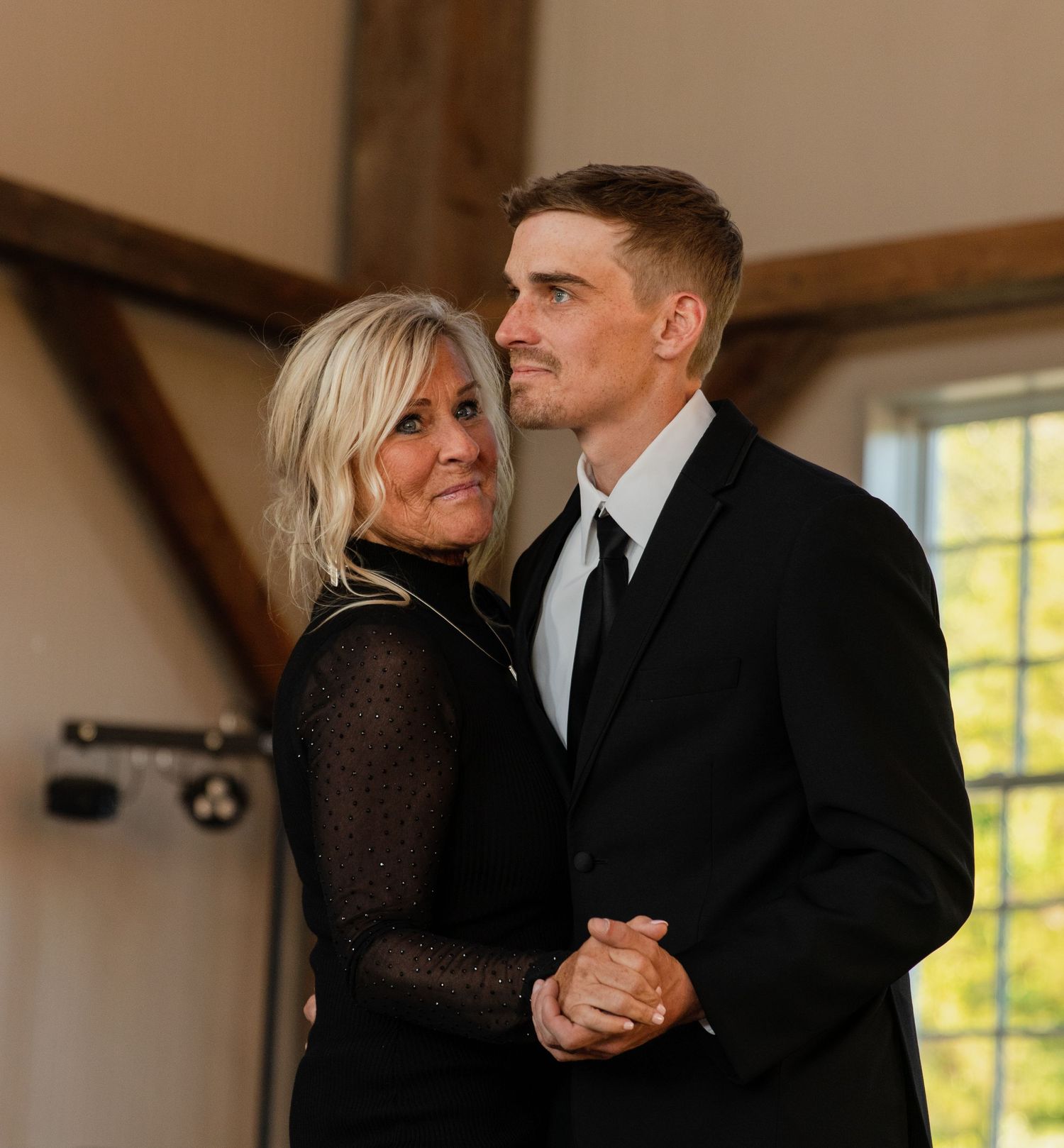 Romantic first dance sequence in a rustic barn venue with wooden beams.