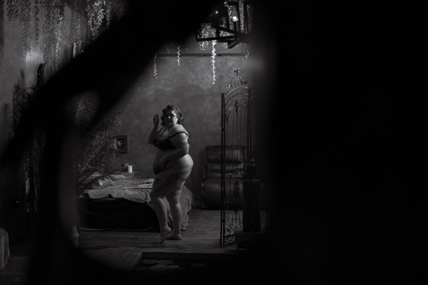 Black and white photograph of a vintage film scene showing small figures through a dark archway, creating a dramatic noir mood.