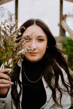 Portrait series showing someone holding flowering branches against a blurred background.