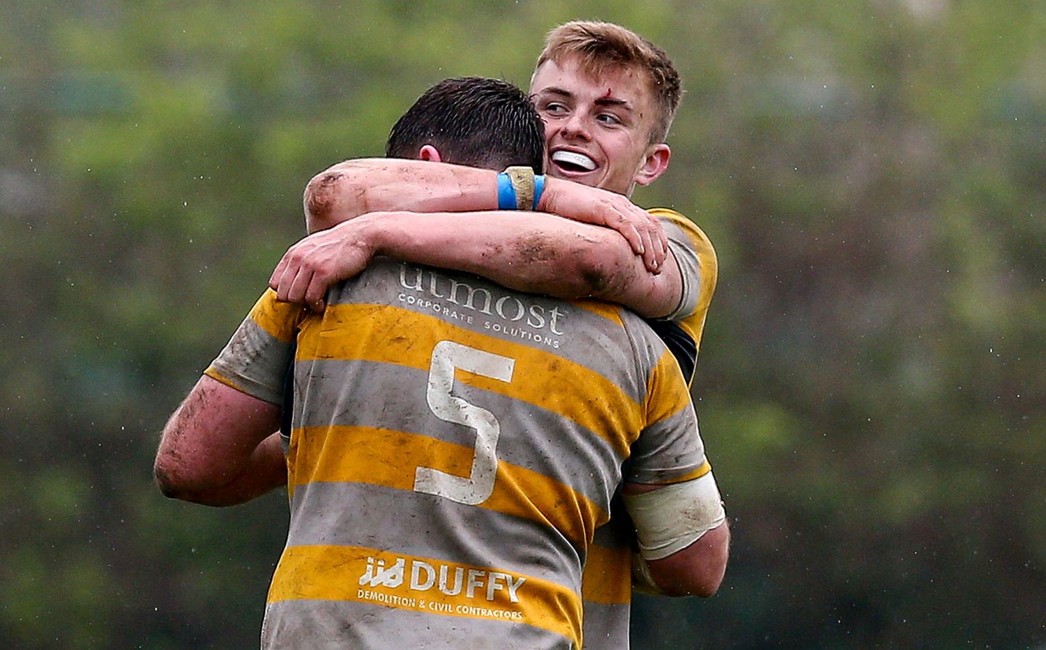 Athletes in yellow striped jerseys celebrate during a competitive match.