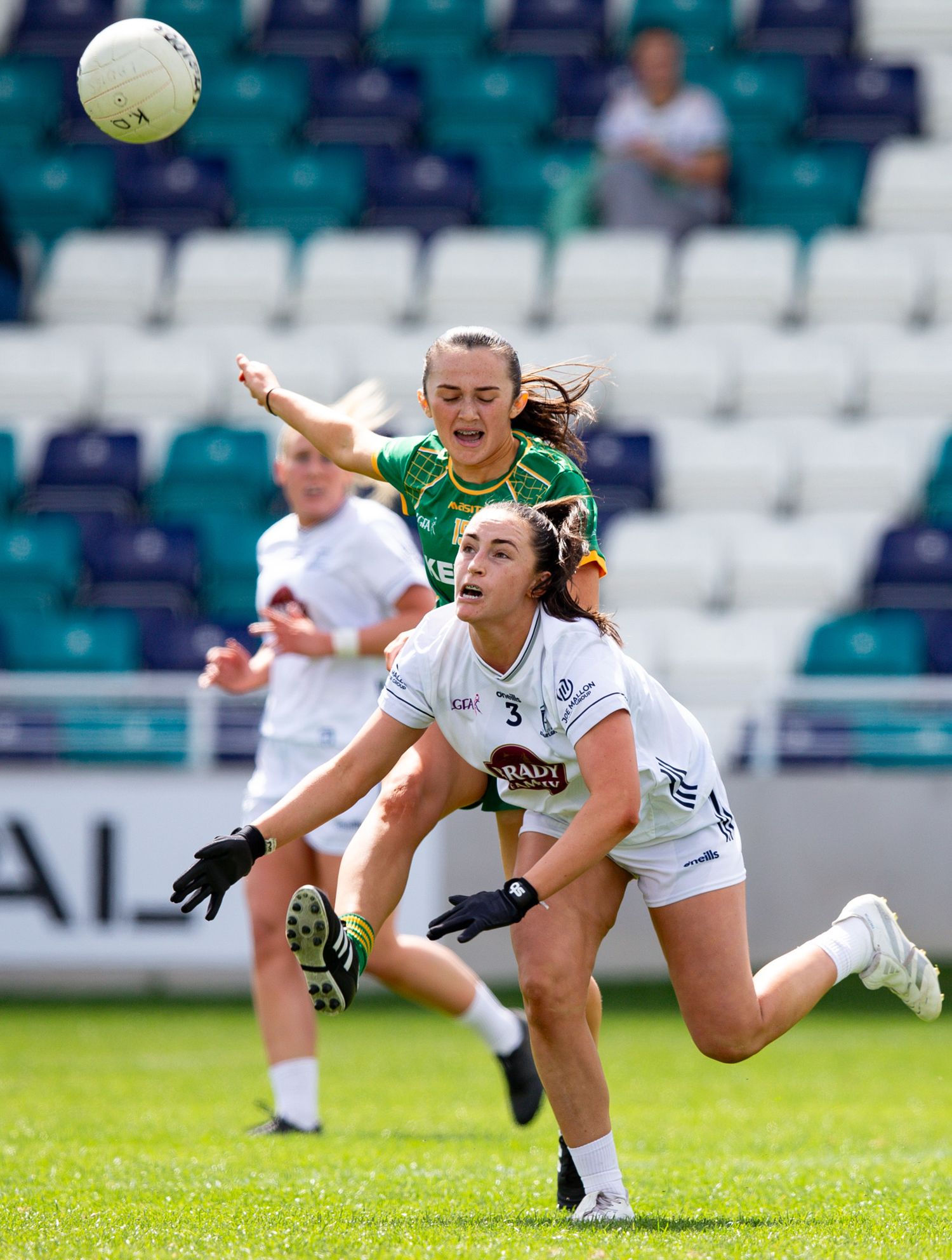 Diving sequence showing players competing for the ball during a women's football match.
