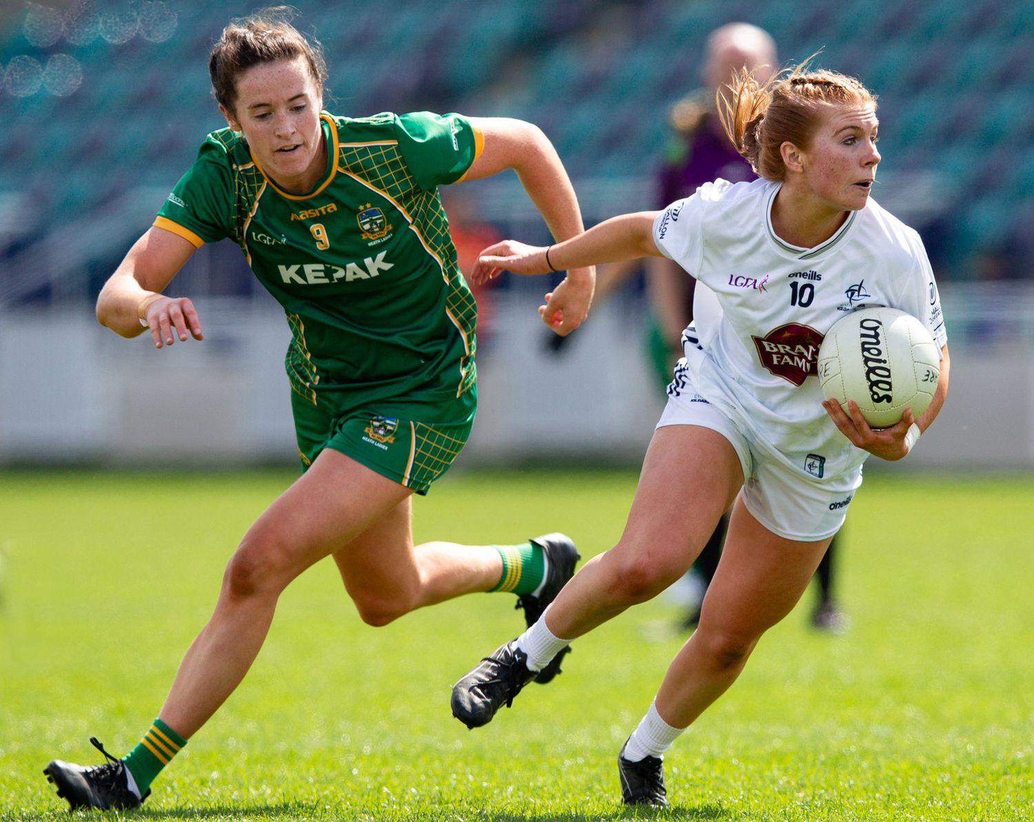 Players making diving tackles and competing for the ball during women's football match.