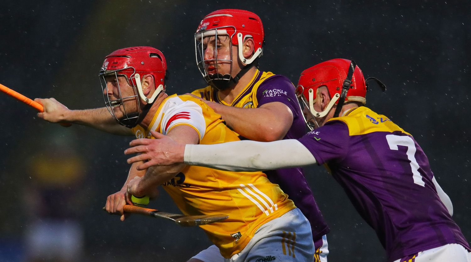 Players in protective helmets compete during a competitive hurling match.