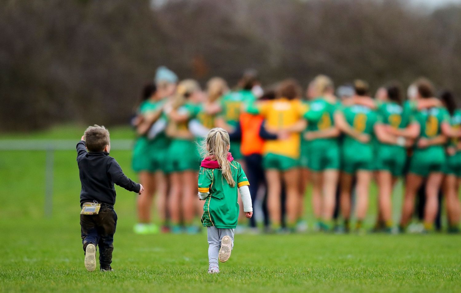 Sports players line up on a grassy field during a team event.