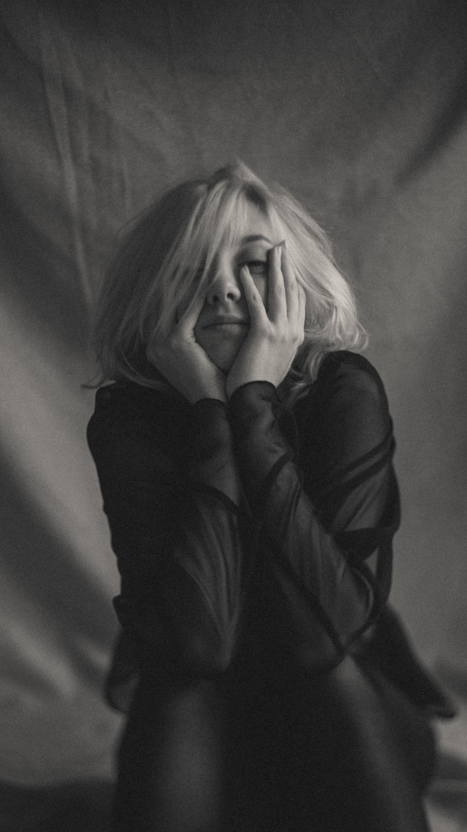 Candid black-and-white portrait of a blonde woman captured during a soulful boudoir session.