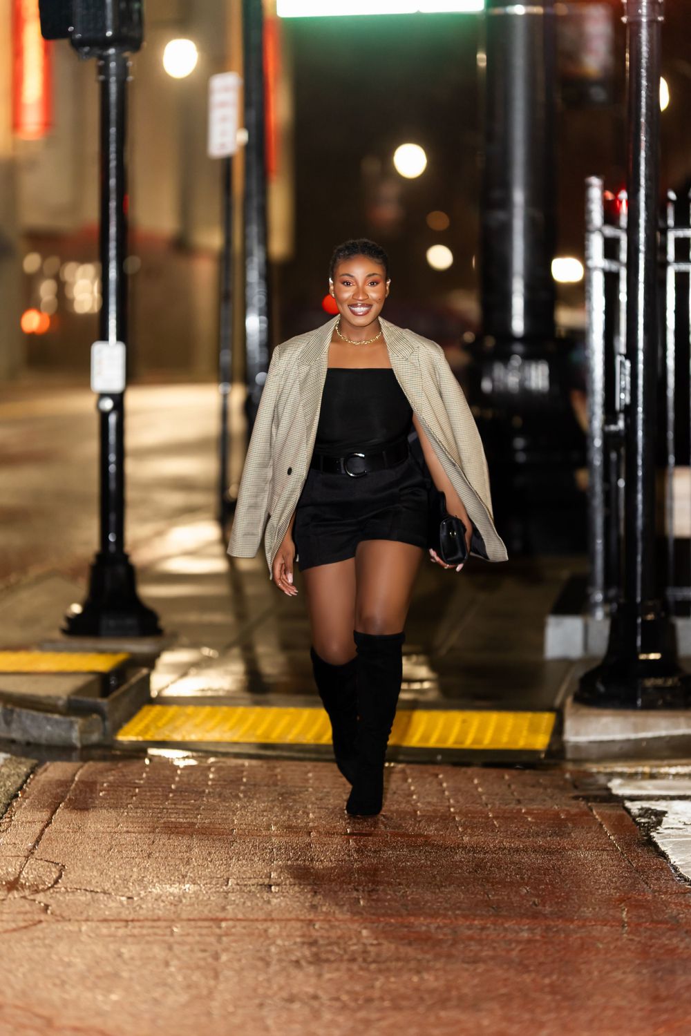 Urban fashion photography on brick pavement with street lamps at night.