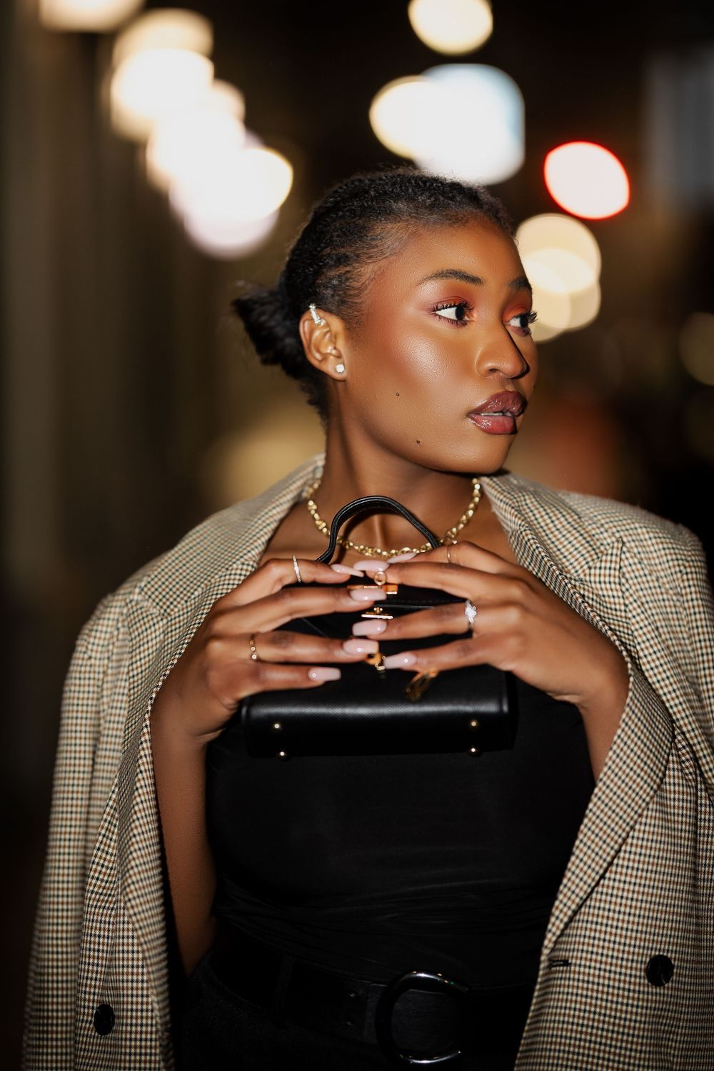 Close-up fashion portrait with beige checkered blazer in evening lighting.