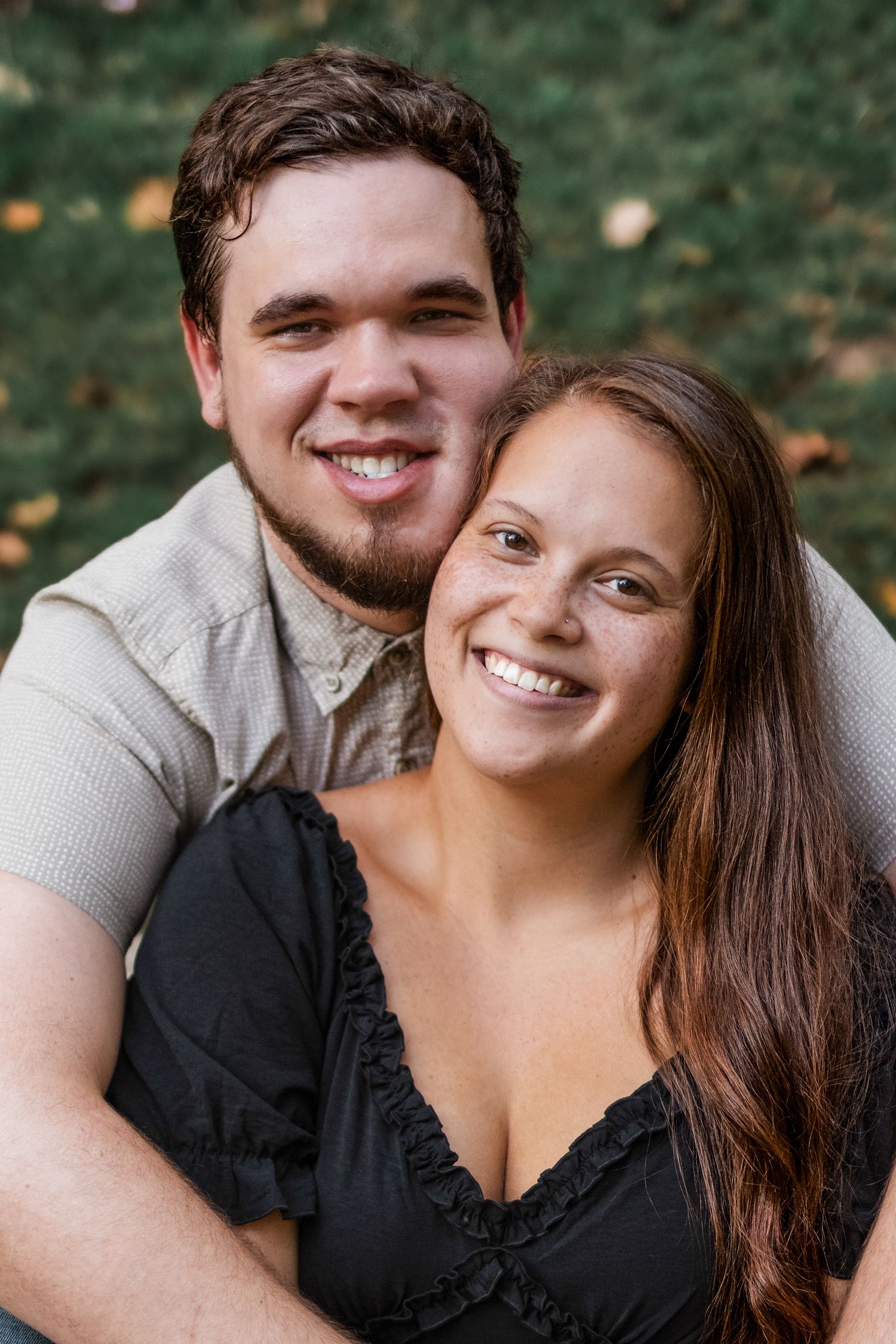 Smiling couple portrait outdoors surrounded by lush greenery, in Windsor Park.