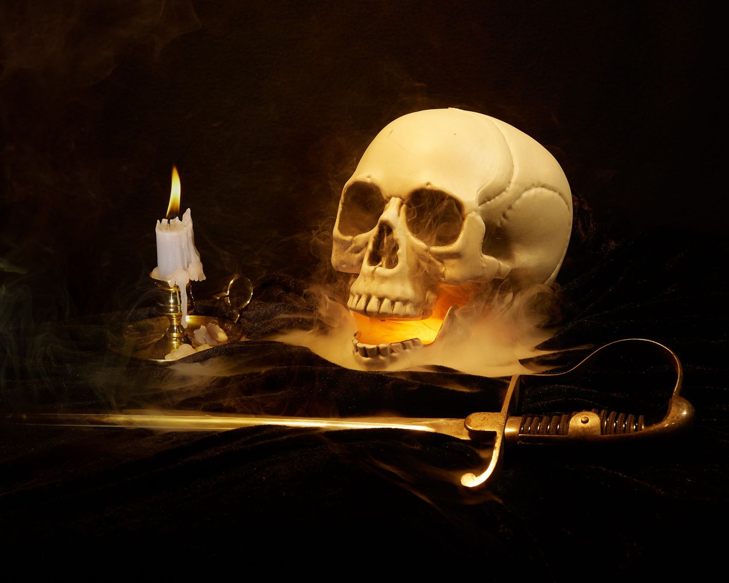 A dramatic vanitas still life featuring a human skull with a lit candle and sward against a dark background.