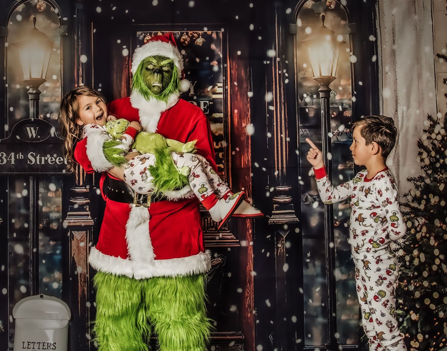 The  in a Santa suit stands at a decorated holiday doorway with children during a festive Christmas photoshoot.