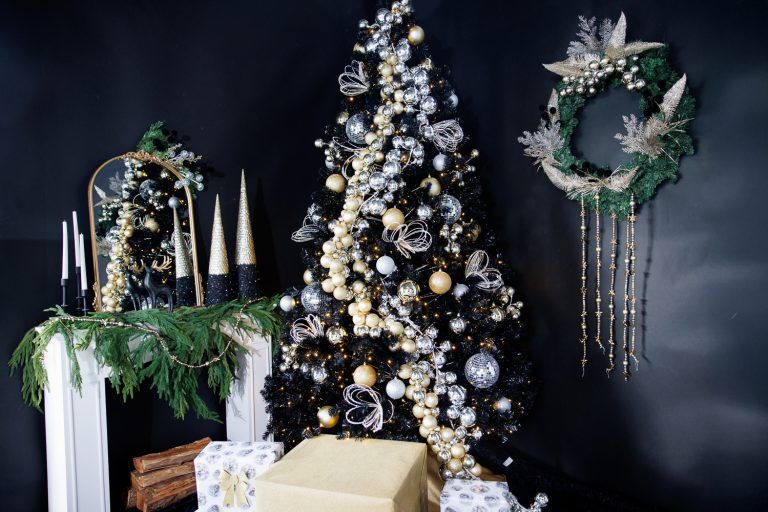 Luxurious Christmas display featuring gold and silver decorated tree, wrapped presents, and elegant greenery.