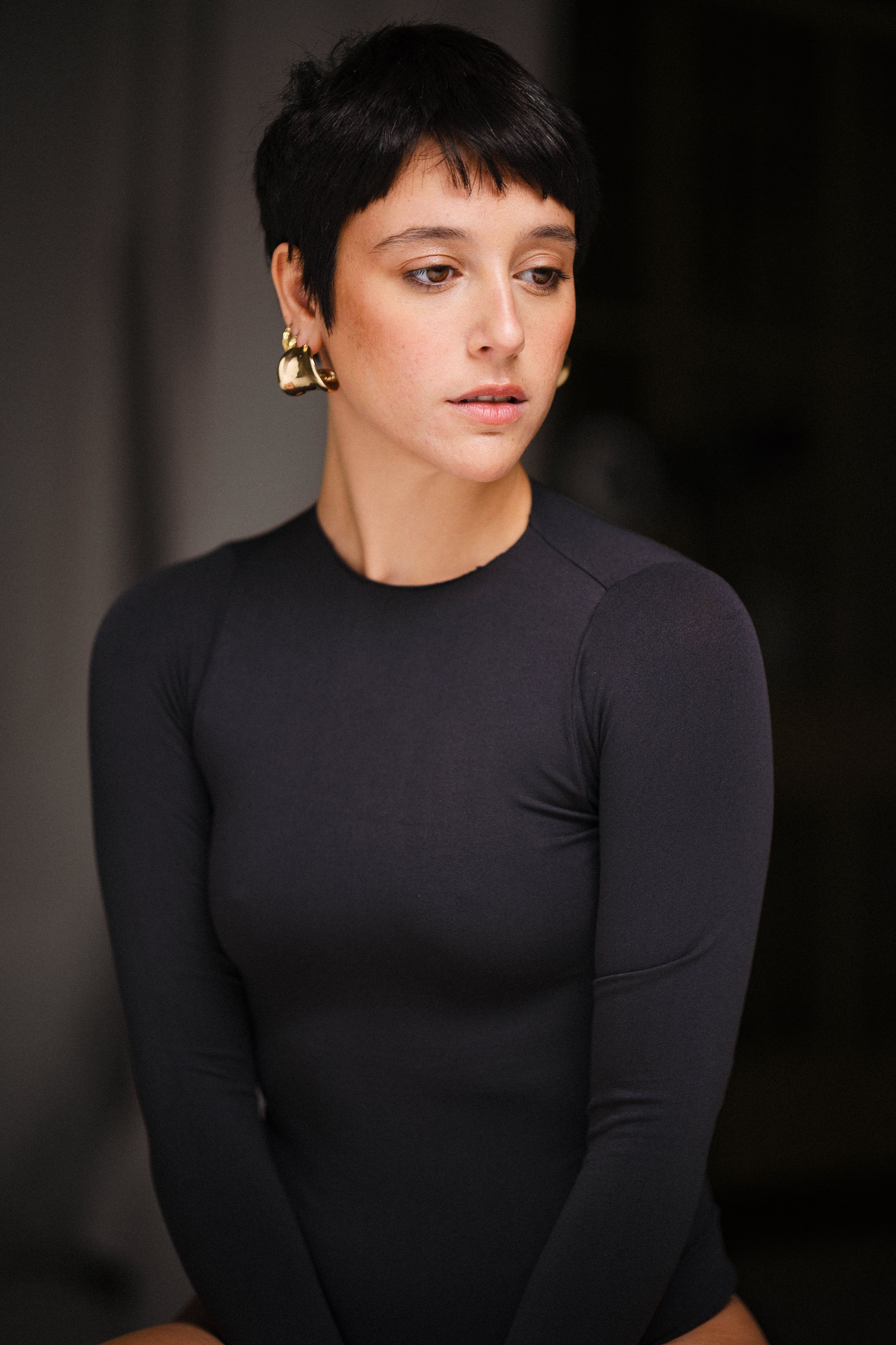 Portrait series showing black long-sleeve bodysuit in dramatic lighting.