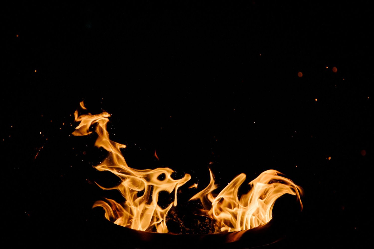 Vibrant orange flames dance against a dark background creating an ethereal fire display.