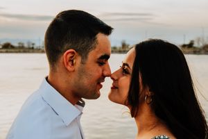 Intimate couple sharing a romantic moment at sunset by a serene waterfront.