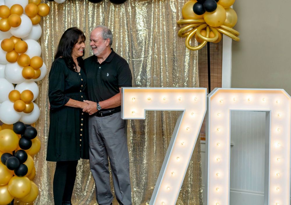 couple at birthday party with festive standing lights