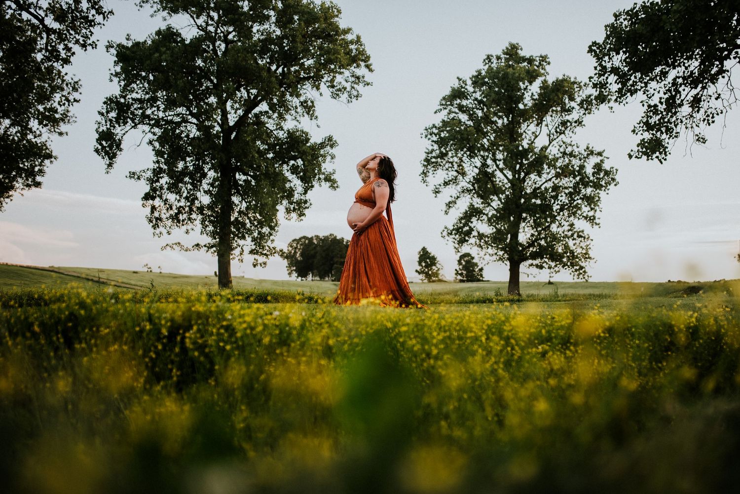Maternity mother in a field of flowers while wearing client closet in Fort Campbell, Tennessee.