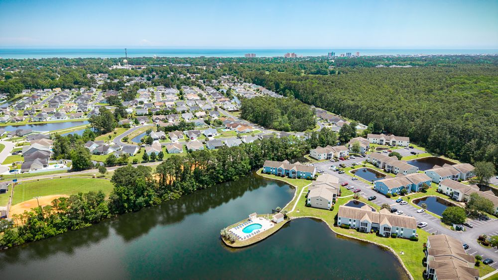 Aerial view of waterfront community with curved shoreline and residential development.