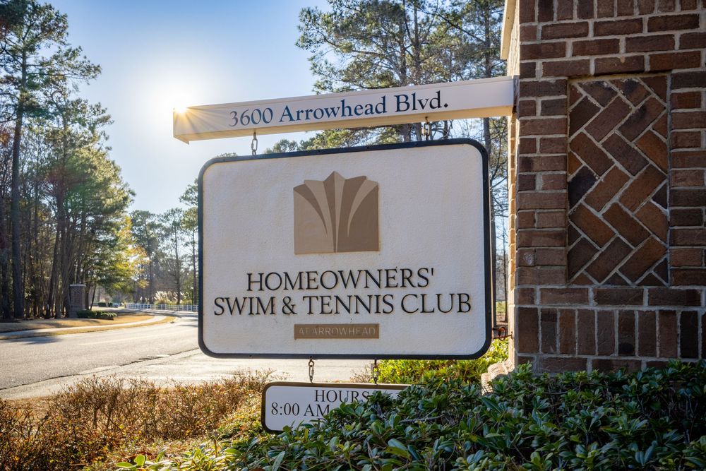 Homeowners' Swim & Tennis Club entrance sign with sun flare.