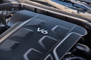 Close-up view of a luxury vehicle's V6 engine compartment with carbon fiber style cover.