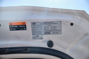 Vehicle information and safety sticker inside white car door frame.