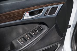 Car interior door panel showing power window controls and wood trim accents.