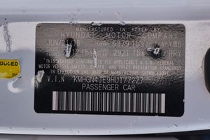 Vehicle identification number plate with serial codes mounted on car body.