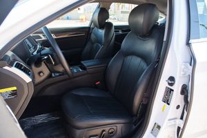 Black leather front seats in a luxury vehicle interior with power adjustment controls visible on the door panel.