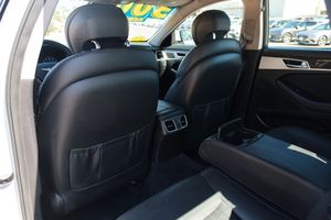 Black leather rear seats of a luxury car interior with seatback storage pockets and center armrest.