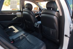 Rear seat interior of a Genesis sedan showing black leather seats and rear climate controls.