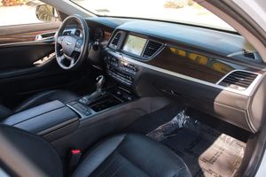 Luxury car interior showing leather seats, wood trim, and modern dashboard with integrated display screen.