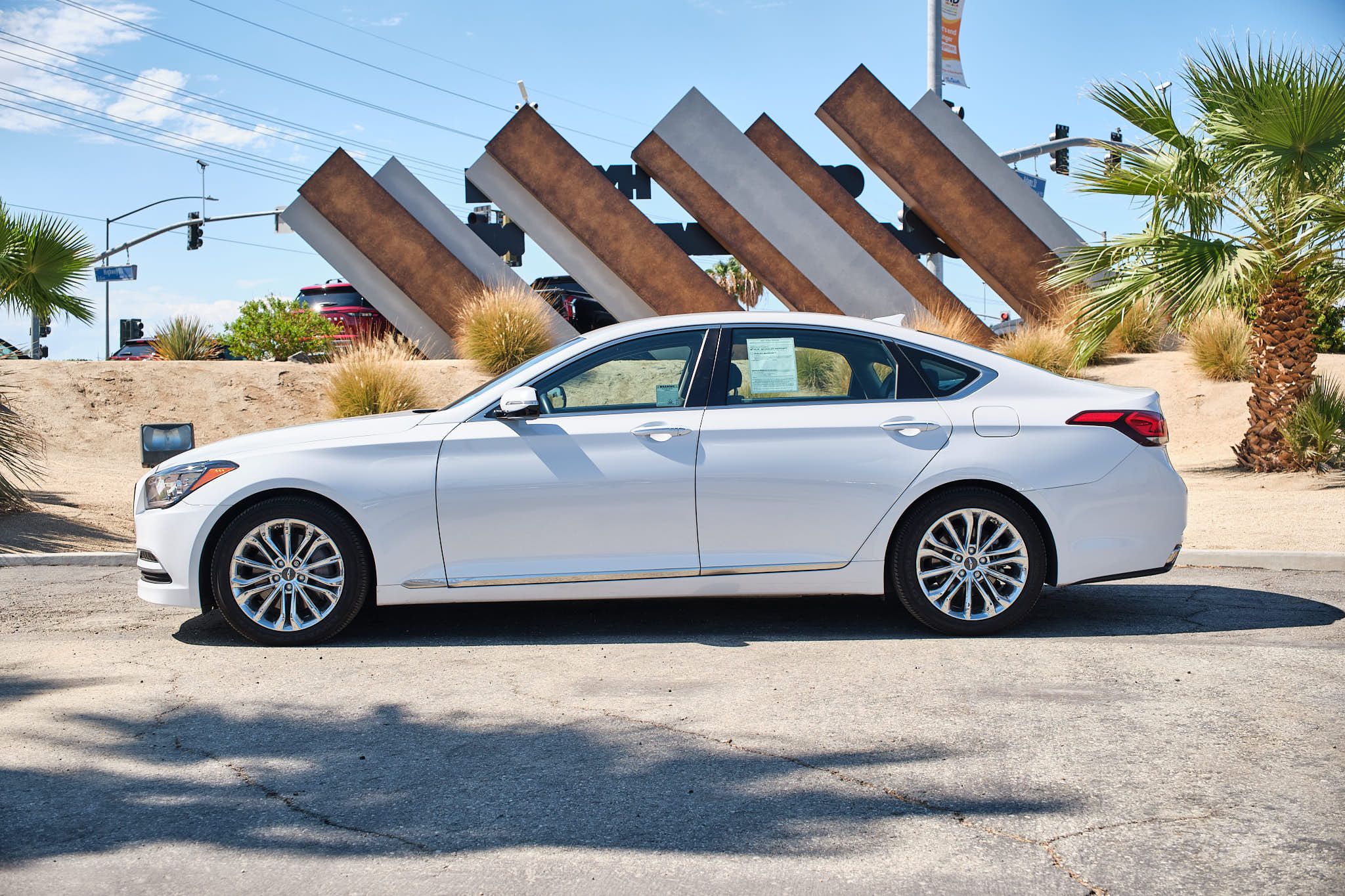 Side profile view of white Hyundai Genesis G80 sedan showing sleek design lines and alloy wheels.