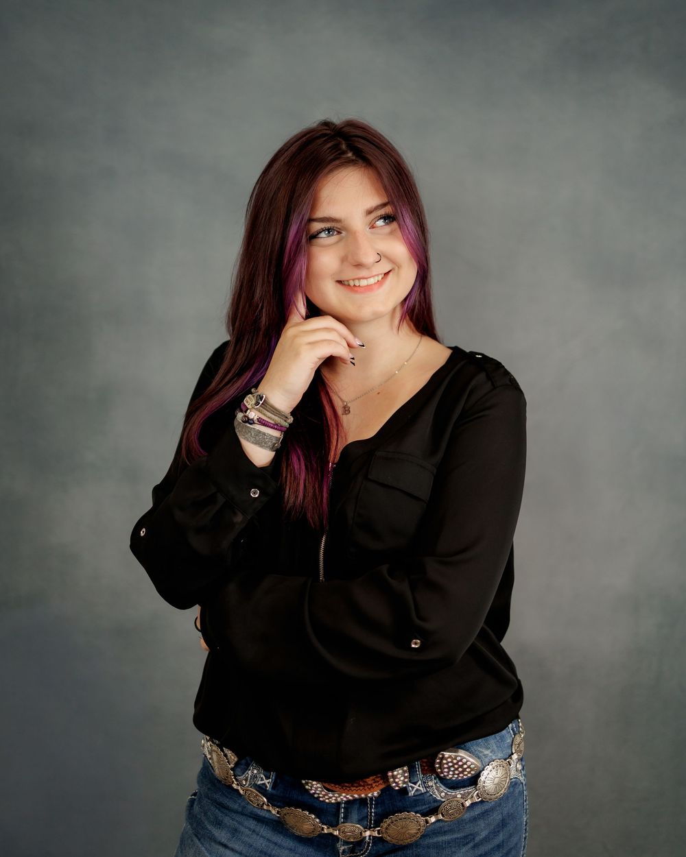 A portrait series showing joyful expressions and poses in a black top against a gray studio backdrop.