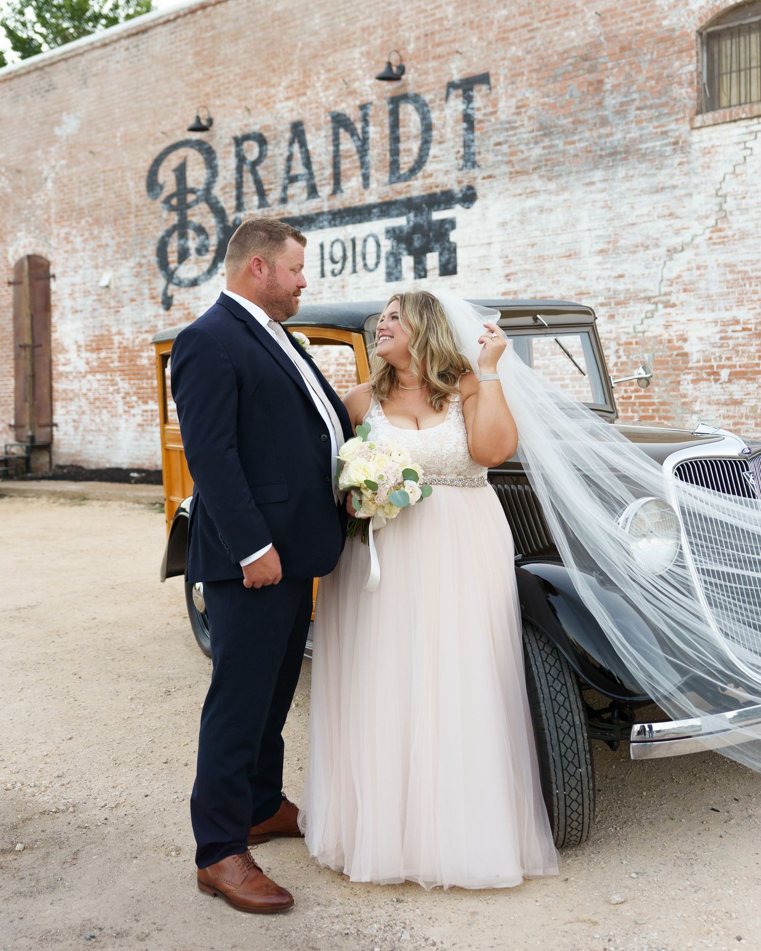 A couple shares a romantic first dance at their wedding reception beneath elegant floral decorations.