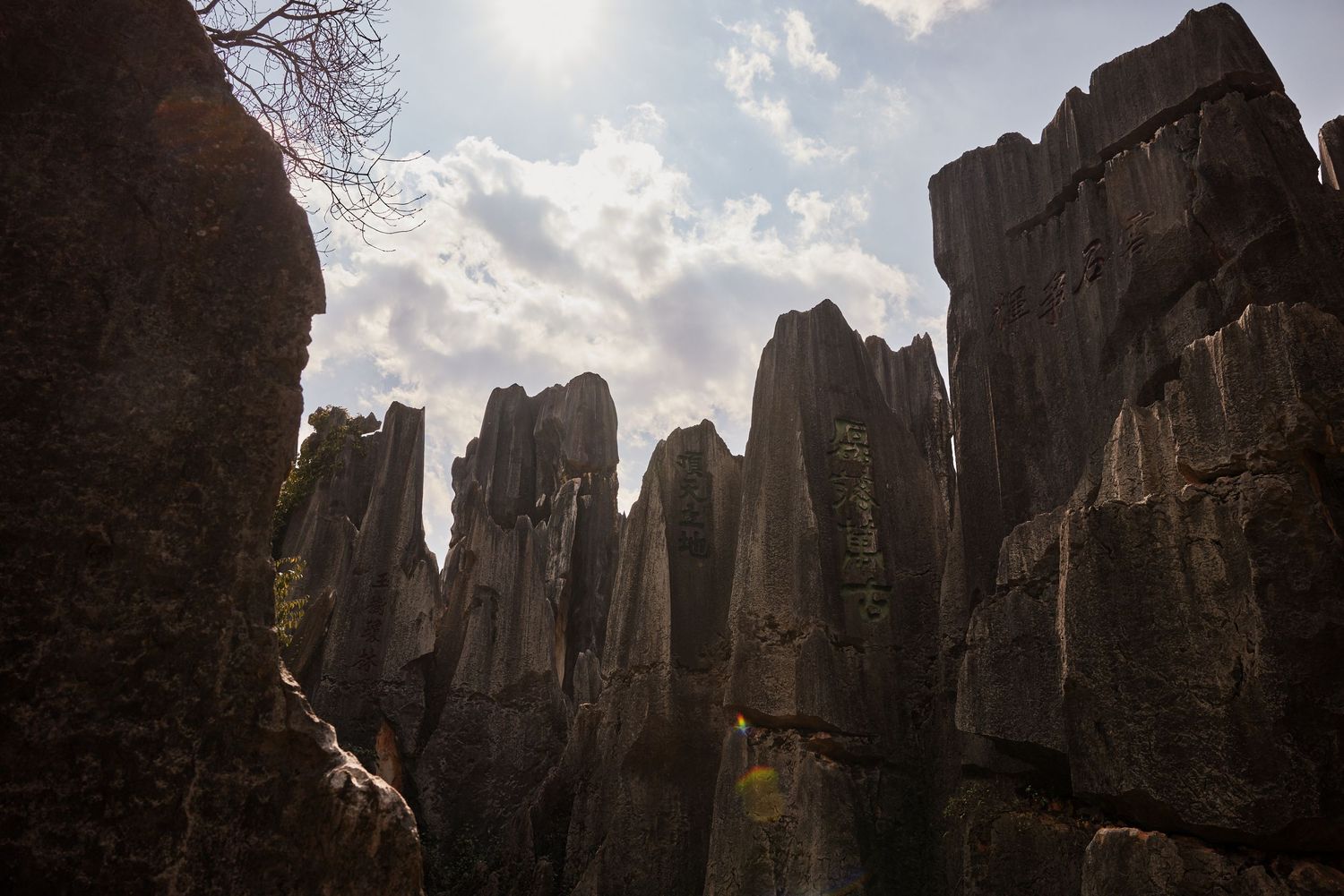 Dramatic rock formations rise against a cloudy sky at Shilin Stone Forest in China's Yunnan Province.