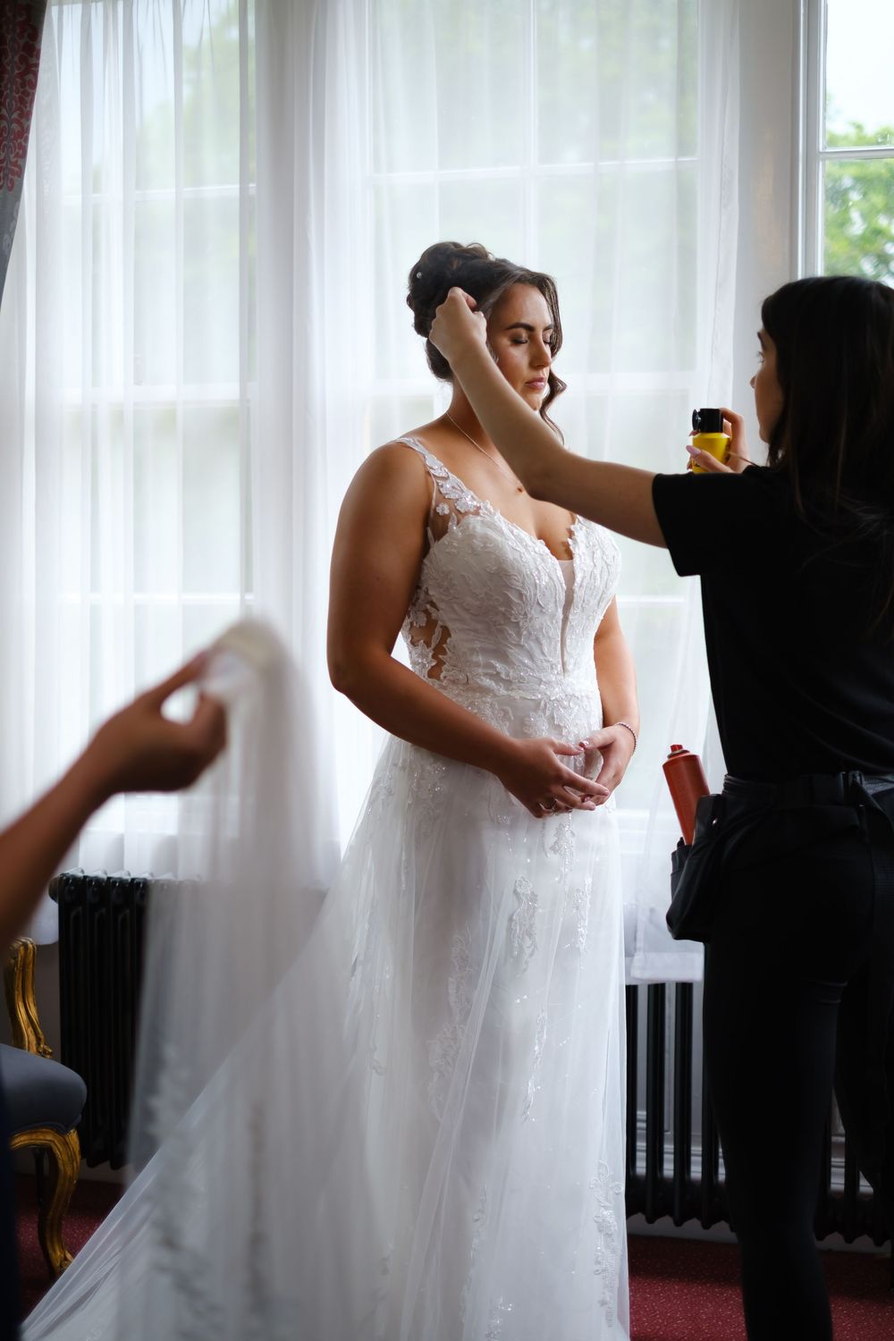 Bride and her hair dressers making final preparations at Weetwood Hall