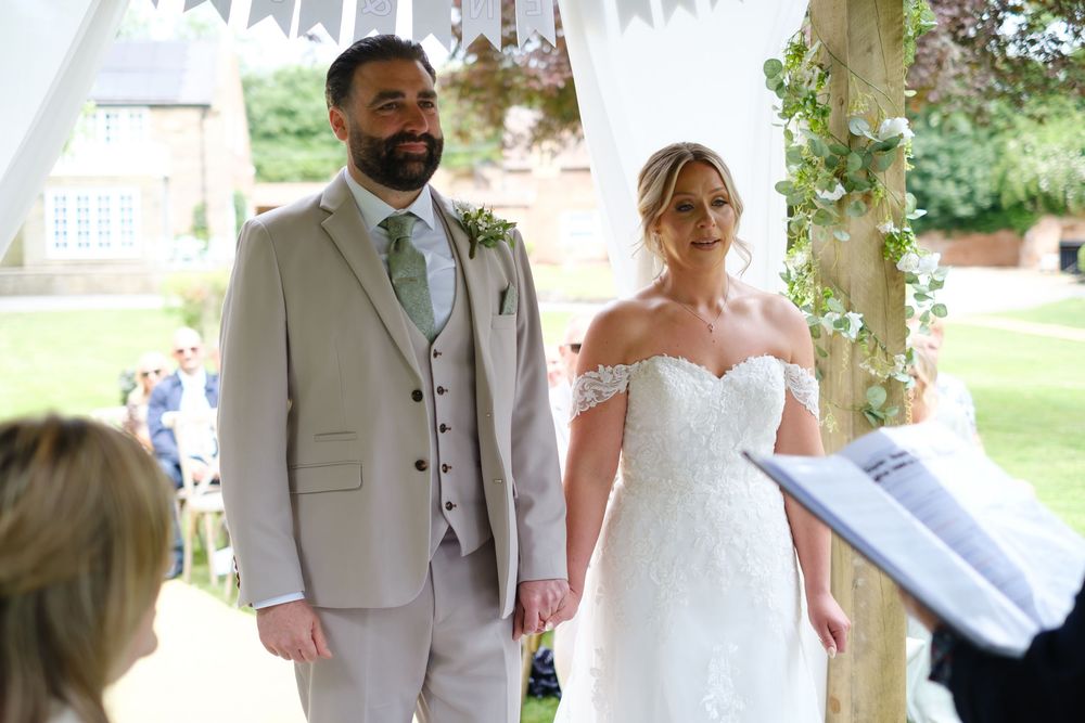 Bride and Groom at the front of the aisle at the outside wedding at The Old Vicarage, Elskesley