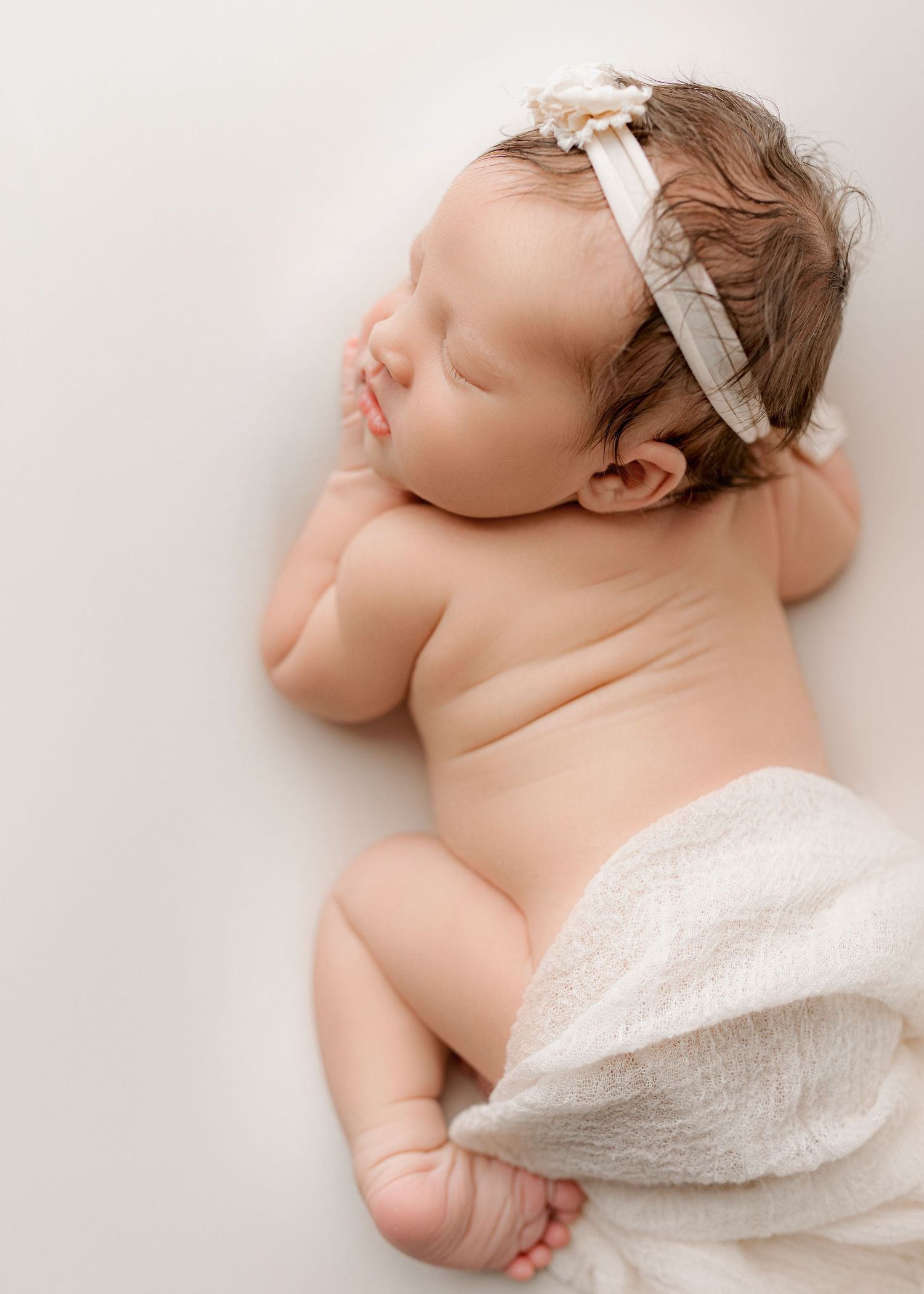 Baby girl on white backdrop posed.