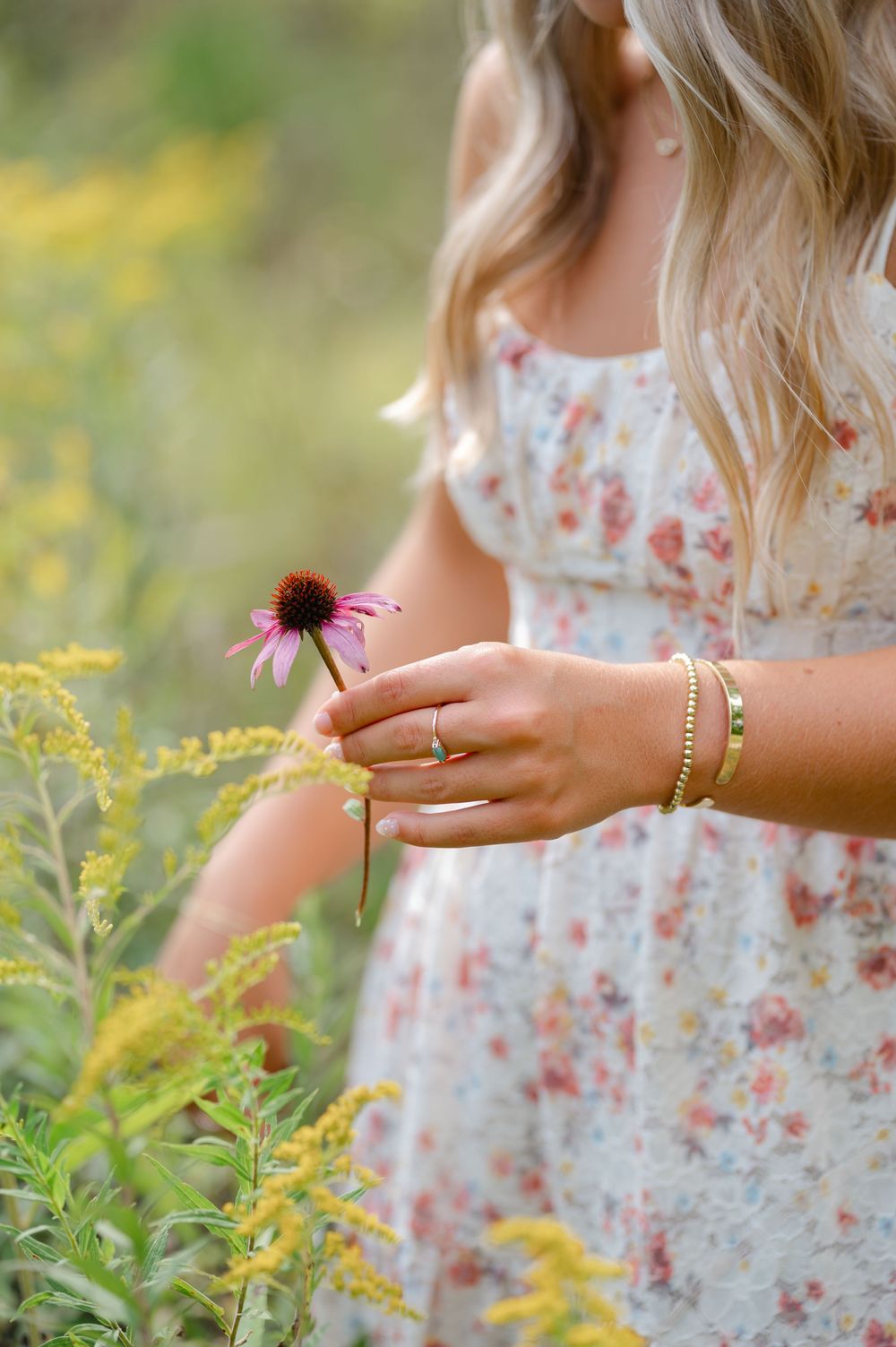 detail shot of seniors nails and jewelry picking a flower