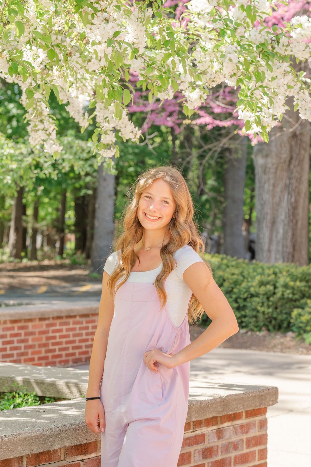 senior in front of flowing trees