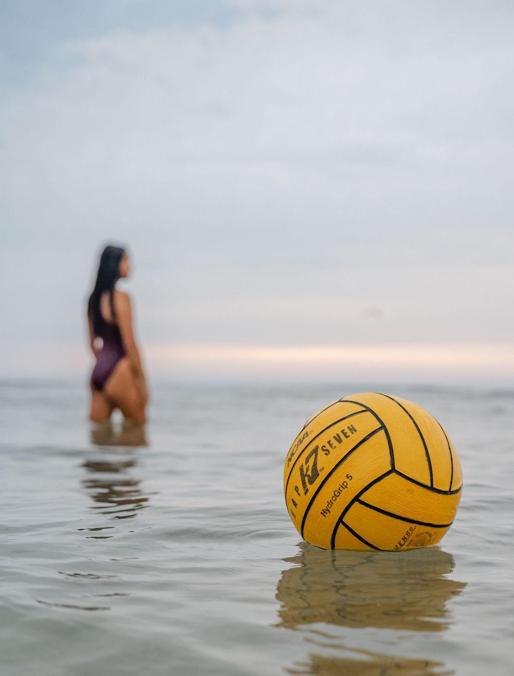 shot of water polo ball in the water with a senior in the distance