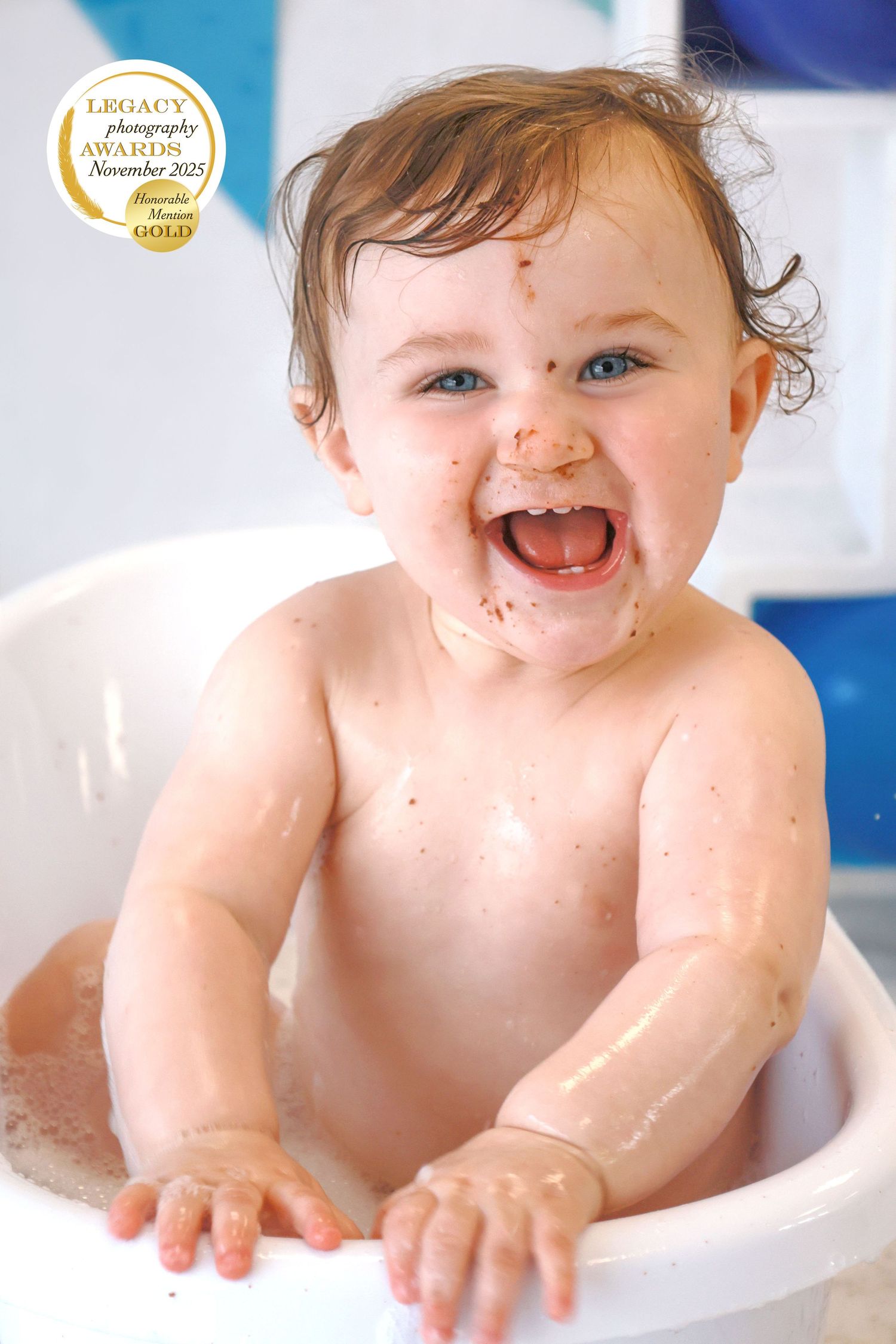 First birthday cake smash setup with blue and white balloons against light blue background.