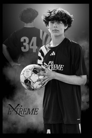 Black and white portrait of a young soccer player holding a ball wearing a black adidas Extreme jersey with number 34 behind.