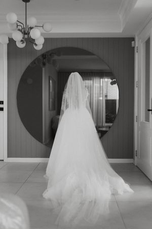 Black and white photos of flowing wedding dress in an elegant interior space.