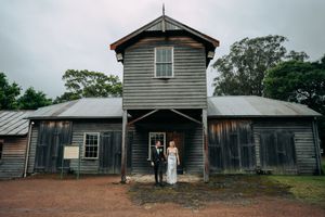 Rustic wooden farm buildings create an atmospheric backdrop for wedding photography.