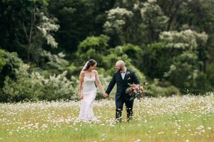Romantic wedding photos captured in a meadow filled with blooming white daisies.