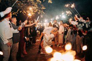Wedding guests celebrate with sparklers creating a magical nighttime atmosphere.