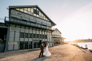 Waterfront wedding venue at sunset with dramatic lighting and coastal views.