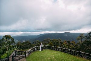 Panoramic mountain landscape view with misty clouds and lush greenery.